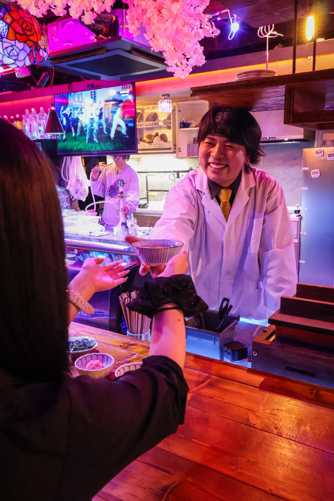 カウンター越しに料理を手渡すスタッフ